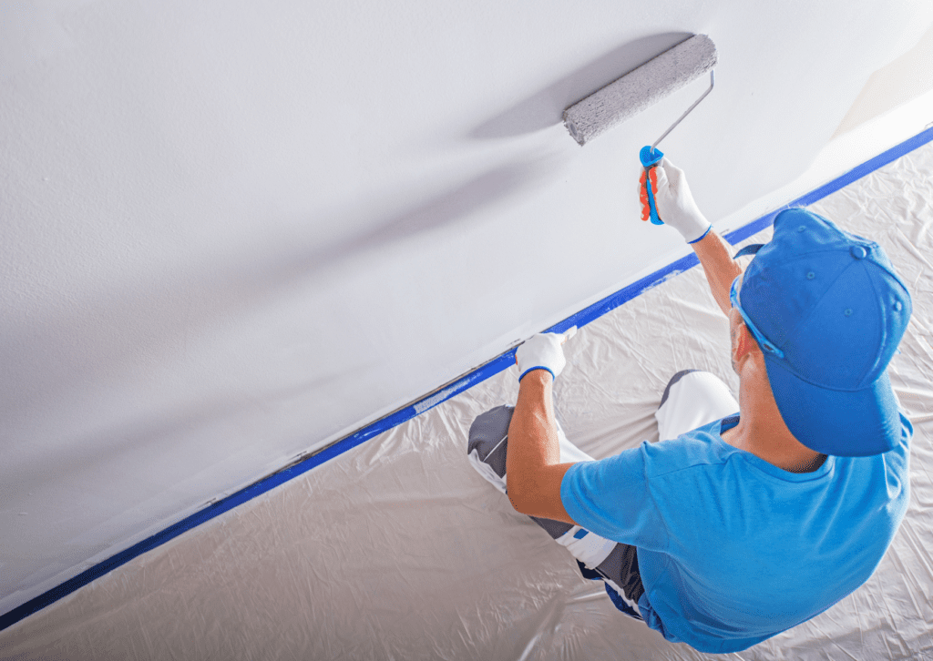 A painter is applying a fresh coat of paint on a ceiling, showcasing Colorado commercial residential painting work.